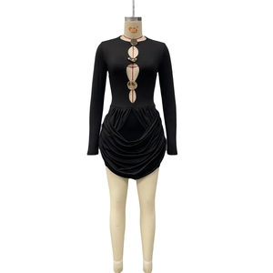 Close-up of hollow out chest detail with gold metal ornaments on a black knit dress