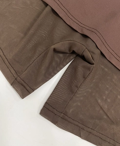 Detailed macro view of brown knit fabric stitched with mesh paneling and visible seams