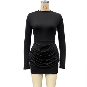 Detail view of the ruched texture and elastic fabric on a black bodycon mini dress