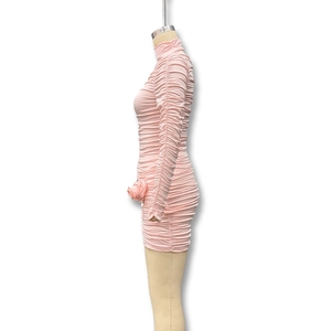 Close-up of ruched pink mini dress featuring side 3D floral applique and high neckline