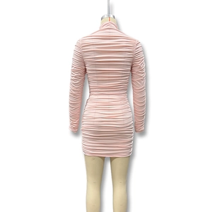 Detail of light pink bodycon dress featuring elegant horizontal ruching and slim fit design