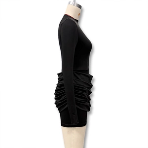 Detail of the black ruched mini dress showing the side texture and slim fit silhouette