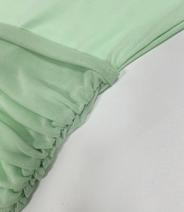 Detail of mint green ruched mesh stitching on a slim backless dress for women