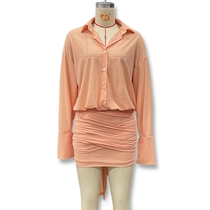 Detail view of the pleated skirt texture and V-neck chiffon shirt in peach pink