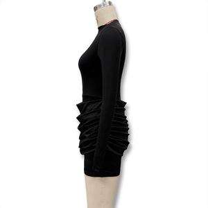 Detail view of black bodycon dress featuring elegant horizontal ruching and slim-fit long sleeves