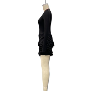 Detail of elegant black long sleeve dress featuring stylish side pleats and ruched hem design
