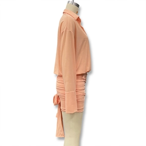 Detail view of apricot two-piece set featuring a ruched mini skirt with back tie detail