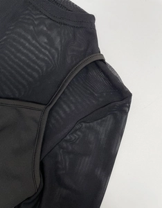 Detailed view of the mesh stitching and neckline of a black long-sleeved sheer bodysuit