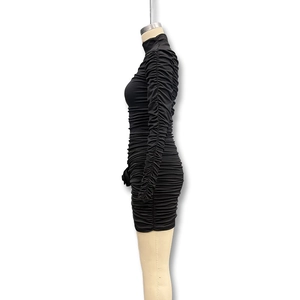 Detail view of the black ruched bodycon dress showing textured fabric and mock neck design