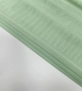 Close-up detail of mint green honeycomb mesh fabric with lightweight texture