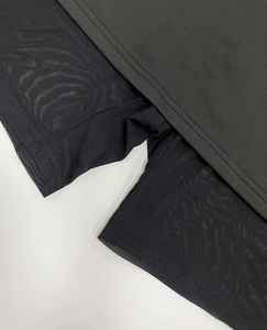 Detail view of dark gray knit fabric with breathable black mesh lining and double-needle stitching
