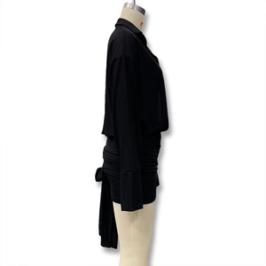 Side view of black slim-fit dress with ruched skirt and long sleeves on mannequin