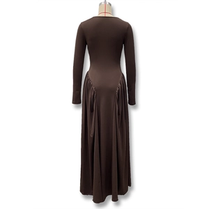 Detail view of the back seams and pleated hem on a brown long-sleeved midi dress