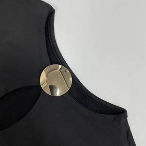 Close-up of black knit dress with hollow cutout and large gold metal ring detail