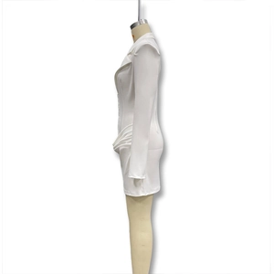 Dettaglio delle pieghe in vita e del drappeggio laterale su un abito blazer bianco