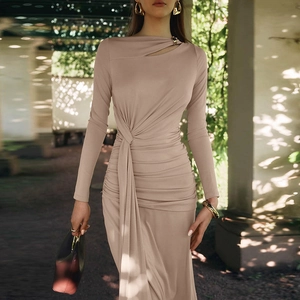 Détail de la robe abricot avec décolleté asymétrique et boucle métallique décorative