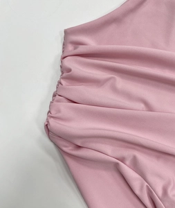Detail shot of pink ruched fabric texture with fine diagonal twill pattern and soft drape