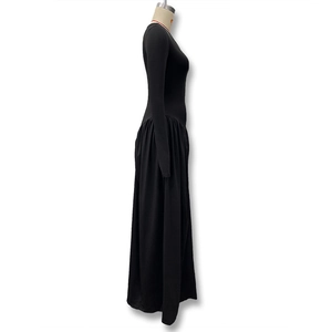 Detail view of waist pleated design on this elegant long-sleeve black maxi dress