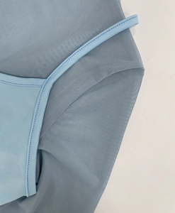 Close-up of light blue mesh fabric detail with fine texture and high quality stitching