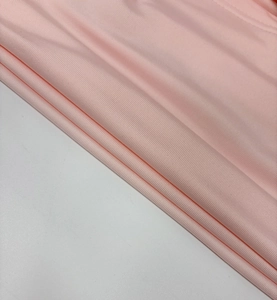 Detailed macro view of soft pink ribbed fabric texture with elegant pleated folds