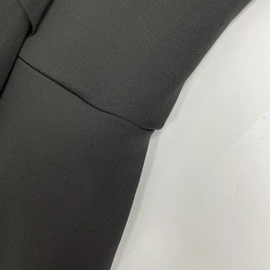 Vue détaillée de la couture de qualité sur le tissu d'une robe noire en maille à col V