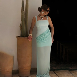 Detail of mint green ruched midi dress showing side drapery and sheer hem texture