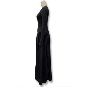 Detail shot of the waist pleats and fabric texture on a long-sleeve black maxi dress