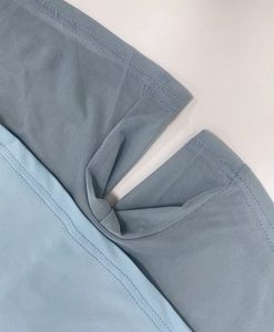 Detailed close-up of double-layered fabric stitching with breathable mesh and elastic material