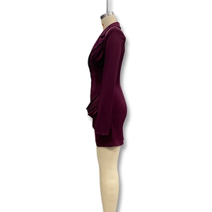 Dettaglio dell'abito bordeaux a maniche lunghe con eleganti arricciature laterali e vestibilità