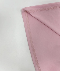 Close-up of high-density overlock stitching on pink pleated long sleeve dress fabric