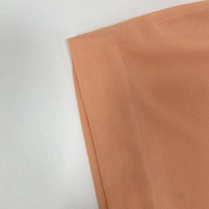 Detailed close-up of pink-orange ribbed knit fabric showing soft elastic texture