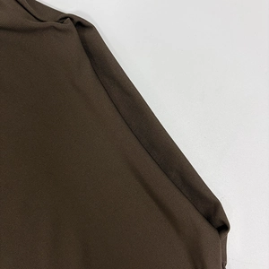 Macro shot of dark coffee brown ribbed knit fabric with professional overlock stitching