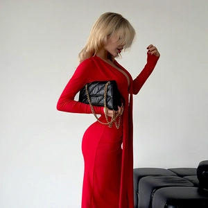 Détail d'une robe moulante rouge avec col en V profond et sac à main matelassé noir