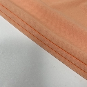 Close-up of peach orange ribbed knit fabric texture showing elastic weave detail