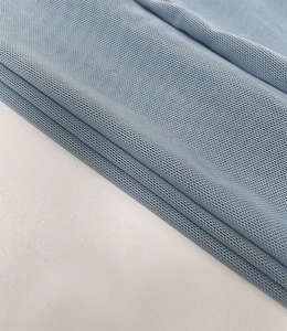 Detailed macro shot of light blue breathable piqué mesh fabric with knit texture
