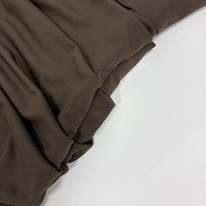 Detailed macro view of the brown ribbed knit fabric showing soft texture and stitching