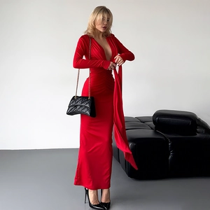 Détail de la robe rouge à manches longues avec décolleté en V et ruban à la taille