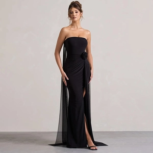 Detail of elegant black strapless evening dress with rose appliqué and sheer mesh tail