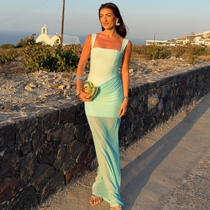 Detail of light green ruched bodycon dress with sheer mesh panel at sunset