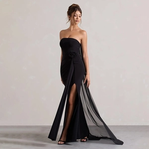 Detailed view of the handcrafted 3D floral accent and high slit on a black evening gown