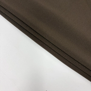 Detailed macro view showing the fine knit texture and drape of dark brown bodycon dress fabric