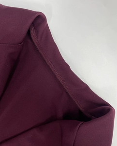 Dettaglio macro delle cuciture rinforzate ad alta densità sullo scollo dell'abito viola