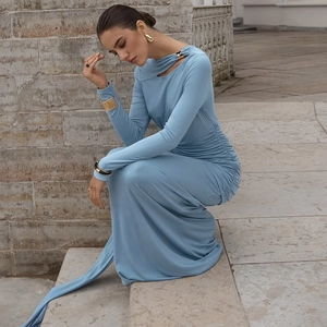 Détail d'une robe bleu clair ajustée avec plis à la taille et garniture dorée