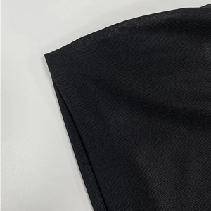 Close-up of black ribbed knit fabric detail showing texture and vertical stripe pattern