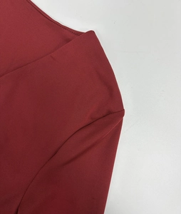 Macro shot of double-needle stitching on deep red knit dress with a sexy V-neck detail