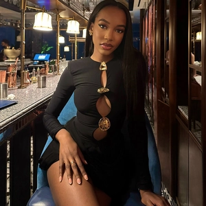 Close-up of black bodycon dress featuring gold buckle accents and elegant hollow-out details