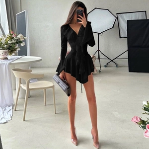 Détail d'une robe noire à col en V avec manches évasées et ourlet à volants asymétriques
