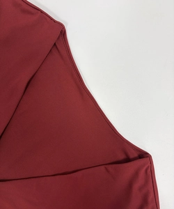Close-up of wine red stretch fabric with fine texture and durable double-stitched hem