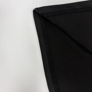 Close-up of double-stitched hem and premium black fabric texture on bodycon dress