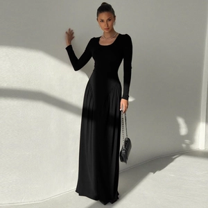 Detail of elegant black long sleeve maxi dress with pleated skirt and quilted chain bag